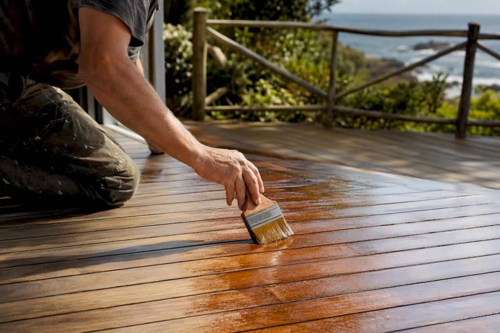 Applying penetrating oil finish to wooden deck